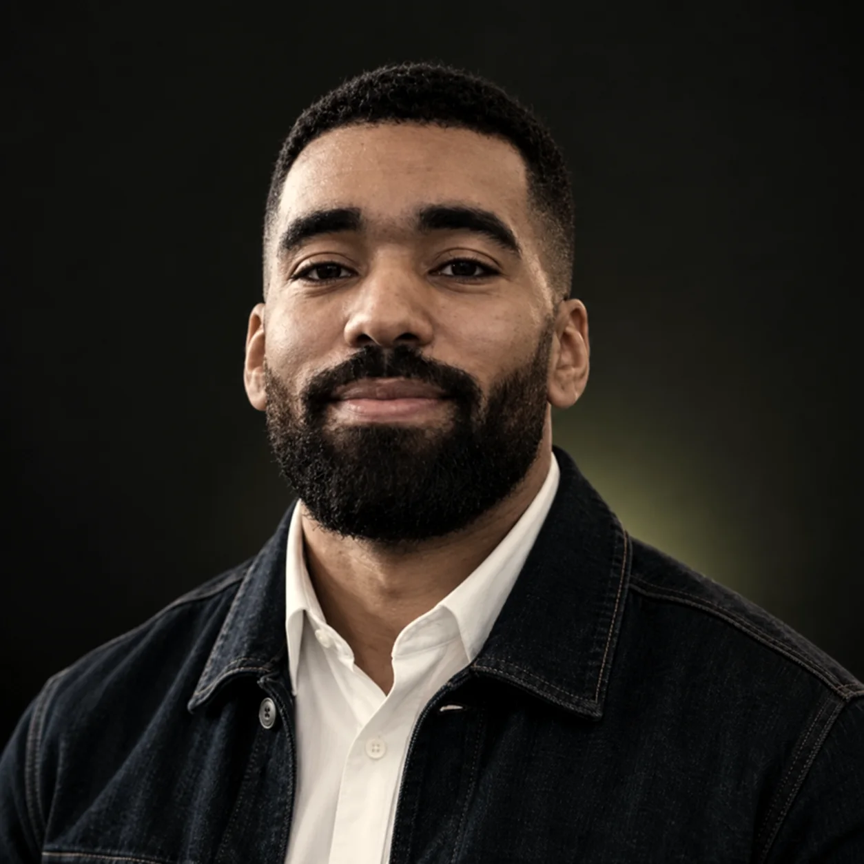 Portrait de Rayan Mpondo, veste en jean sur chemise blanche